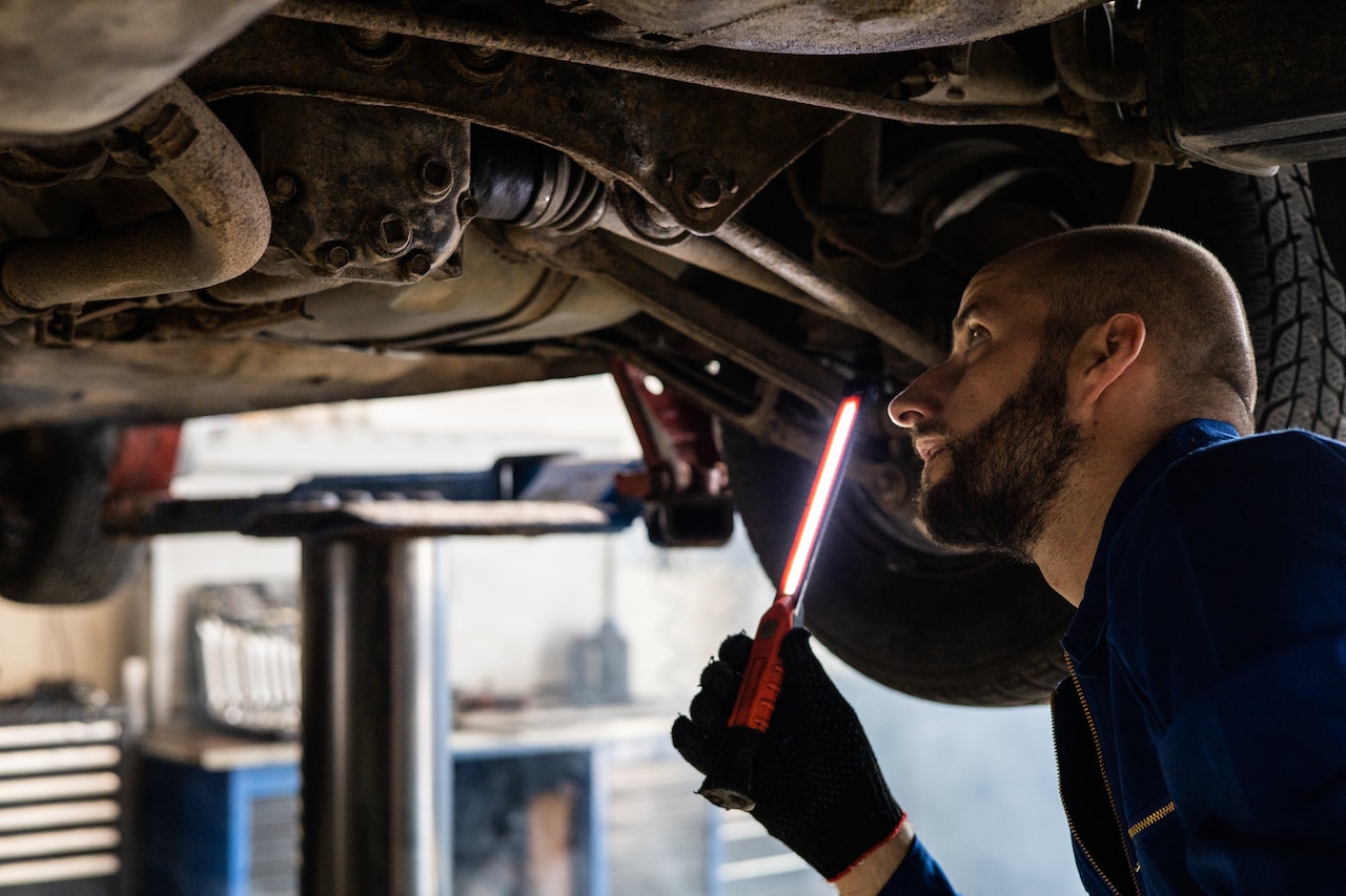 car-mechanic-inspecting-under-a-car
